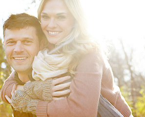 Image showing Fun in the Fall. A happy man piggybacking his girlfriend while spending time in the woods.