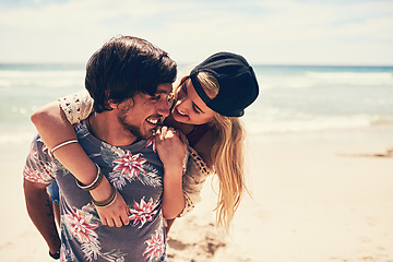 Image showing Bonding on the beach. an attractive young woman getting a piggyback from her boyfriend on the beach.