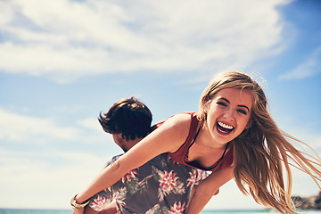 Image showing Fun times on the beach. Portrait of an attractive young woman being carried by her boyfriend on the beach.