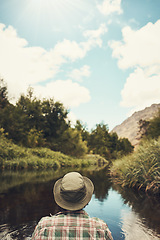 Image showing Spending the day in serenity. Rearview shot of a young man going for a canoe ride on the lake.