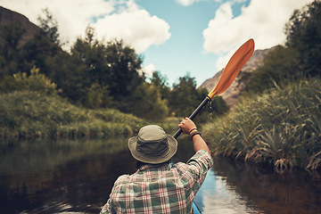 Image showing Paddling towards a new adventure. Rearview shot of a young man going for a canoe ride on the lake.