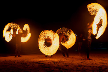 Image showing Fire three ways. a fire performance on a beach in Thailand.