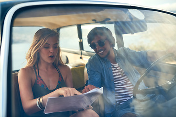 Image showing Lead the way. an affectionate young couple looking at a map during their roadtrip.