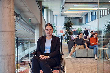 Image showing In a modern office, a young businesswoman in a wheelchair is surrounded by her supportive colleagues, embodying the spirit of inclusivity and diversity in the workplace