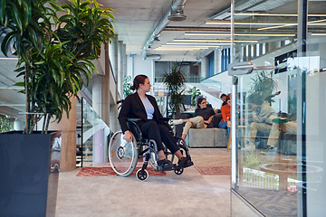 Image showing In a modern office, a young businesswoman in a wheelchair is surrounded by her supportive colleagues, embodying the spirit of inclusivity and diversity in the workplace