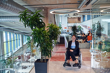 Image showing In a modern office, a young businesswoman in a wheelchair is surrounded by her supportive colleagues, embodying the spirit of inclusivity and diversity in the workplace