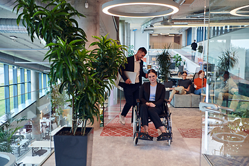 Image showing In a modern office, a young businesswoman in a wheelchair is surrounded by her supportive colleagues, embodying the spirit of inclusivity and diversity in the workplace