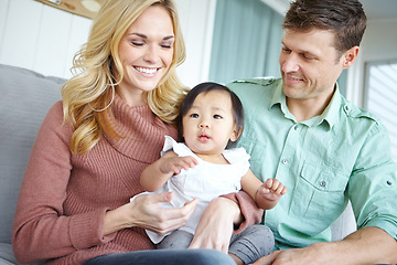 Image showing Adoption has fulfilled our lives. A happy couple spending time with their beautiful adopted daughter while at home.