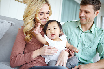 Image showing Adoption Making dreams come true. A happy couple spending time with their beautiful adopted daughter while at home.