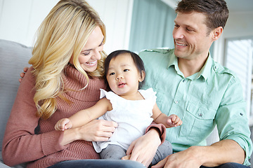 Image showing Youre too cute, arent you. A happy couple spending time with their beautiful adopted daughter while at home.