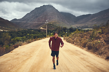 Image showing Clocking some fitness hours along the scenic route. Portrait of a young man out for a trail run.