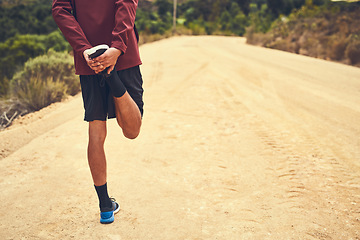 Image showing Getting ready to take on the trail. Rearview shot of a young man warming up before a trail run.