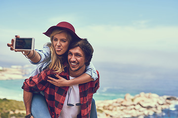 Image showing The perfect spot for a selfie. an affectionate young couple taking selfies while hiking in the mountains.