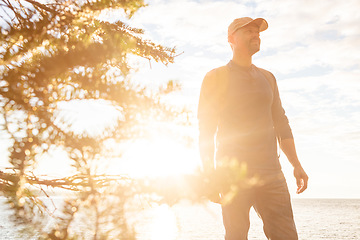 Image showing Hiking is natures therapy. a man wearing his backpack while out for a hike on a coastal trail.