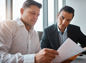 Image showing Working together makes everything easier. two mature businessmen discussing paperwork in a corporate office.