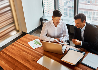 Image showing Success is a decision away. two businessmen having a discussion while sitting by a laptop.