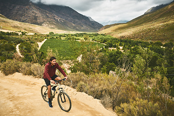 Image showing Cycling along the most scenic route. a young man cycling along a trail.