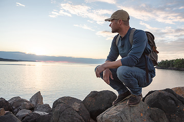 Image showing A good workout isnt the only thing we get from a hike. a man looking at the ocean while out hiking.