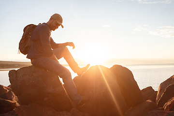 Image showing Im wearing my favourite shoes for this hike. a man wearing his backpack while out for a hike on a coastal trail.