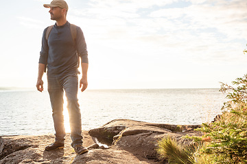 Image showing I love hiking because it brings me back to simplicity. a man wearing his backpack while out for a hike on a coastal trail.