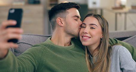 Image showing Couple, sofa and selfie with kiss in home living room with love, care and bonding together for post on web blog. Man, woman and hug with photography, memory and profile picture on social network app