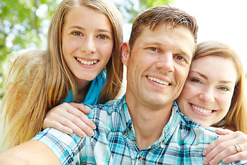 Image showing Proud of my two girls. A happy young family relaxing together on a sunny day.