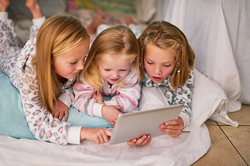 Image showing Bedtime just got a whole lot more interactive. three little sisters using a digital tablet before bedtime.