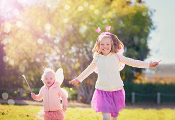 Image showing Make way for the fairies fluttering by. Portrait of two little sisters dressed up as fairies and having fun outside.