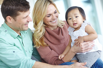 Image showing Shes our big girl. A happy couple spending time with their beautiful adopted daughter while at home.