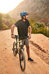 Image showing Its about conquering yourself first beyond the mountain. a young man looking thoughtful while standing with his bike on a trail.