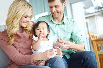 Image showing She makes our family complete. A happy couple spending time with their beautiful adopted daughter while at home.