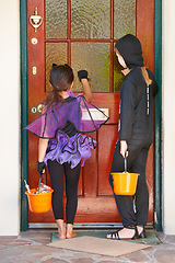 Image showing Tick or treating is so much fun. Rearview shot of some children knocking on a door during halloween.