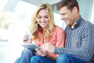 Image showing Grocery shopping together online. a happy mature couple shopping online using a digital tablet while relaxing together at home.