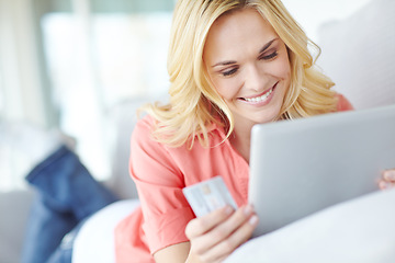 Image showing Doing some shopping on the web. a beautiful young woman using her digital tablet and credit card to shop online.