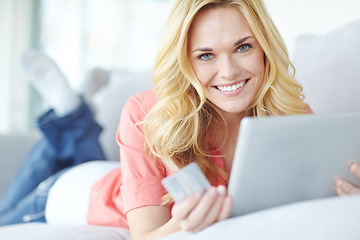 Image showing Loving the freedom of online shopping. Portrait of a beautiful young woman using her digital tablet and credit card to shop online.