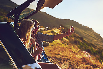 Image showing Roadtripping. a happy young couple posing for a selfie with their car on a roadtrip.