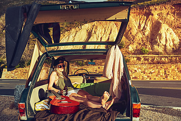 Image showing Im just doing my thing. a young woman relaxing in the back of her car on a roadtrip.