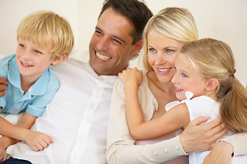 Image showing Enjoying time together. A loving family of four watching television together in the lounge.