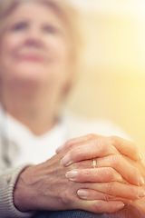 Image showing Aging gracefully is a virtue. An elderly womans hands clasped together on her lap.