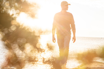 Image showing Hiking is always a good idea. a man wearing his backpack while out for a hike on a coastal trail.