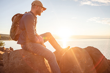 Image showing Go for a hike, stay for the scenery. a man looking at the ocean while out hiking.