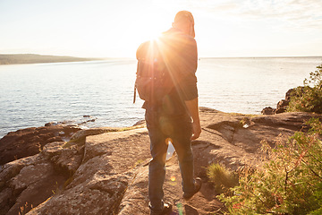 Image showing Hiking is the perfect way to sweat out your frustrations. a man wearing his backpack while out for a hike on a coastal trail.