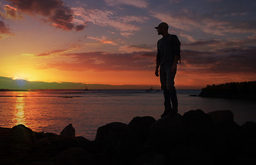 Image showing Im always on an adventure to get closer to the sky. a man wearing his backpack while out for a hike on a coastal trail.