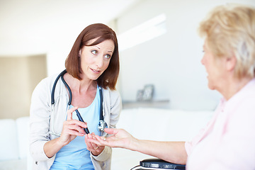 Image showing Well get to the bottom of your faintness - DiabetesSenior Care. Mature nurse checking an elderly patients blood sugar levels with a prick to the finger.