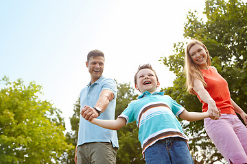 Image showing Fun in the park with mom and dad. Low anlge shot of a family enjoying a walk outdoors.