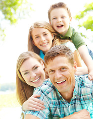 Image showing Sharing matching smiles. A happy young family relaxing together on a sunny day.