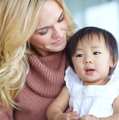 Image showing Shes my blessing. Woman holding an adopted cute baby while sitting inside her home. Mother bonding with her young child. Parent showing love to her kid inside a house. Female caring for her daughter.