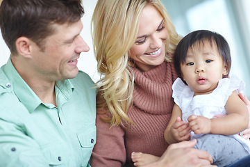 Image showing Our little treasure. A happy couple spending time with their beautiful adopted daughter while at home.