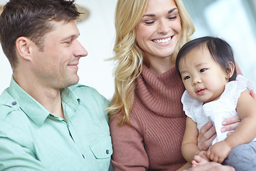 Image showing Shes their angel. A happy couple spending time with their beautiful adopted daughter while at home.