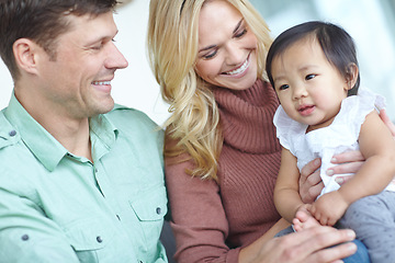 Image showing She completes their life. A happy couple spending time with their beautiful adopted daughter while at home.